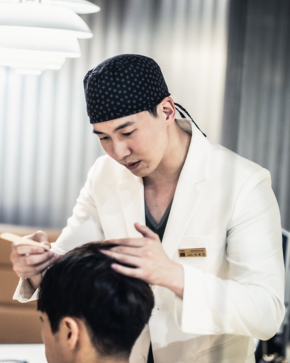 환자의 머리 위에 마커로 헤어라인을 그리는 이재민 대표원장