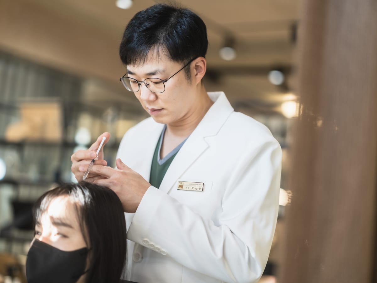 환자의 헤어라인을 살피는 박신웅 원장